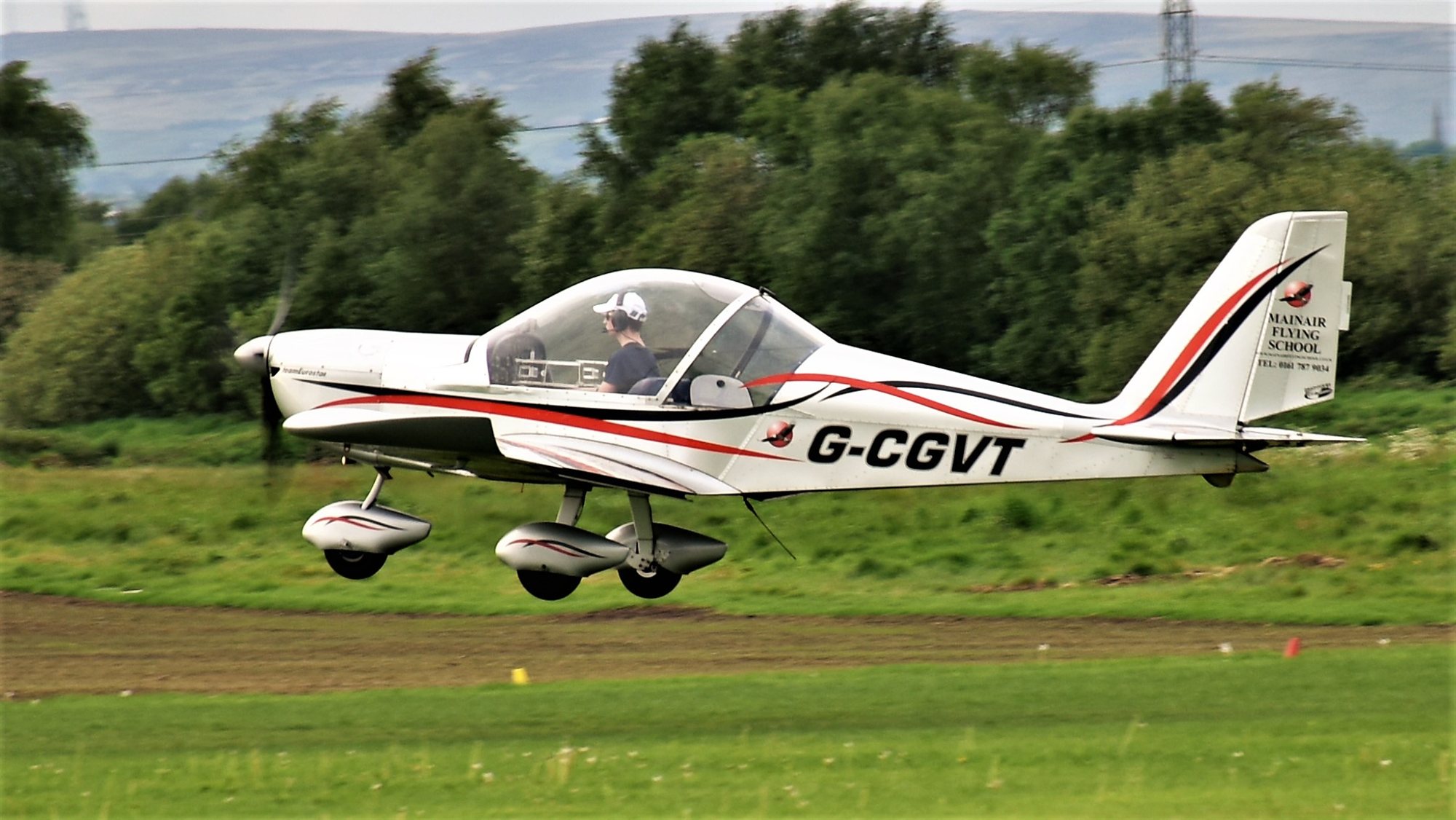 Microlight lifting off from a grass strip